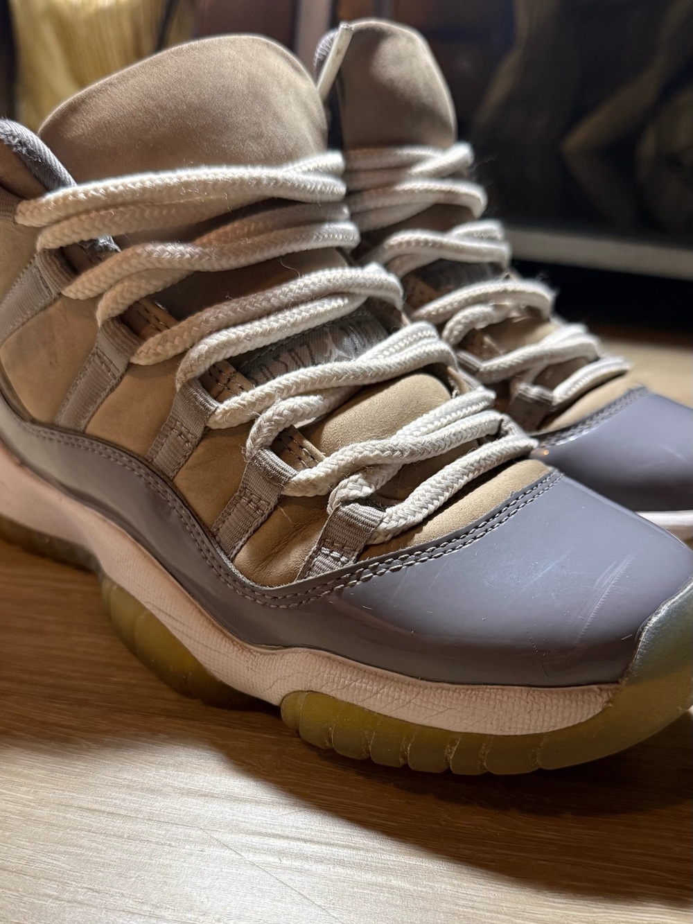 Neutral tan/gray Jordan 11 Low style sneakers with rope laces and translucent ou